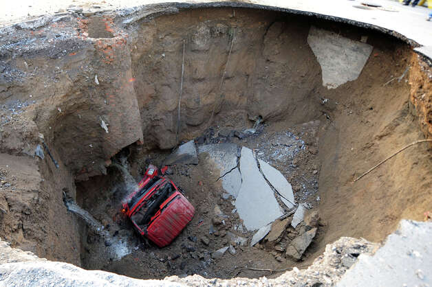 A truck lies in a sinkhole which occurred overnight on Shiliuzhuang 
road, in Beijing on April 26, 2011. A section of the road collapsed 
beneath a truck, slightly injuring the driver and a passenger, who both 
jumped out the vehicle before it sank into the hole, as an authority 
suspects the hole was caused by the construction of a subway line. / 2011 AFP