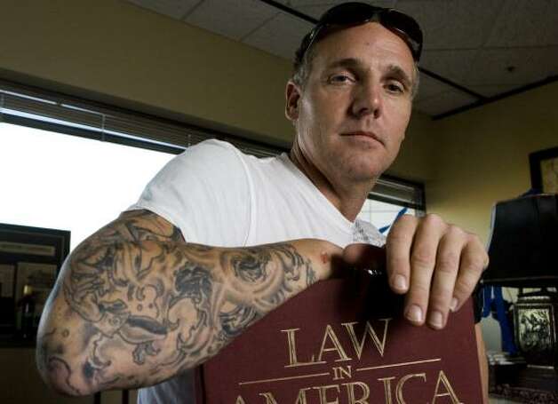 Newly elected State District Judge Kevin Fine shows his tattoos Friday in
