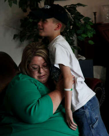 Dana Janczak listens to her 10-year-old son Nathanael's chest after his pulmicort treatment in their rural Cleveland home. Janczak said she and her children suffer from asthma and find access to a doctor difficult. Photo: Mayra Beltran, Chronicle / HC