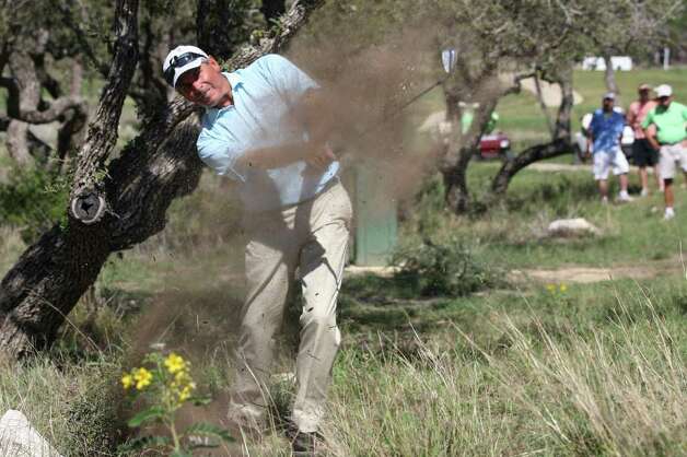 Fred Couples works his way out of the woods off the No