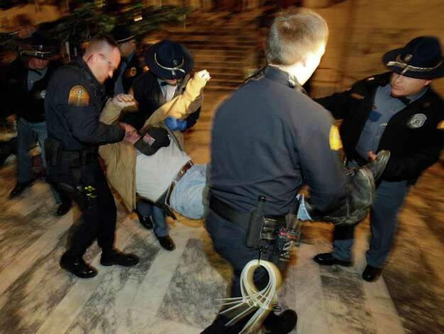 A protester is removed from the Capitol rotunda by Washington State Patrol 