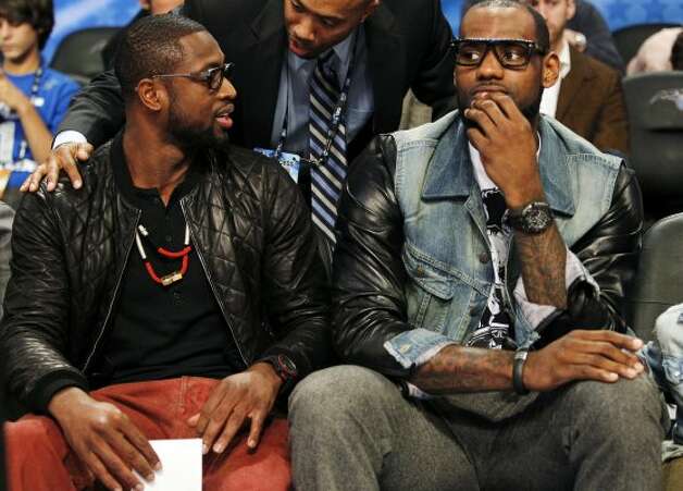 Miami Heat's Dwyane Wade, left, and Lebron James sit courtside during the NBA All-Star festivities in Orlando, Fla., Saturday, Feb. 25, 2012. (AP Photo/Lynne Sladky) (AP) / SA