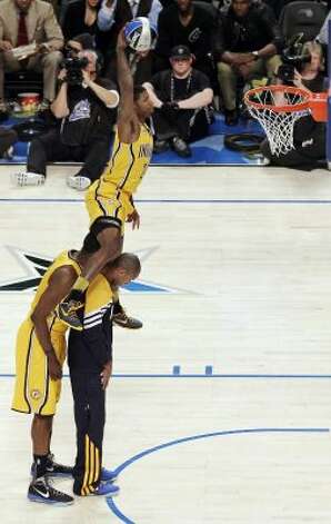 Indiana Pacers' Paul George jumps over two teammates on his attempt during the NBA basketball All-Star Slam Dunk Contest in Orlando, Fla., Saturday, Feb. 25, 2012. (AP Photo/Chris O'Meara) (AP) / SA