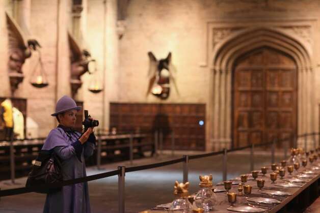 A woman dressed as Fleur Delacour walks through the Great Hall