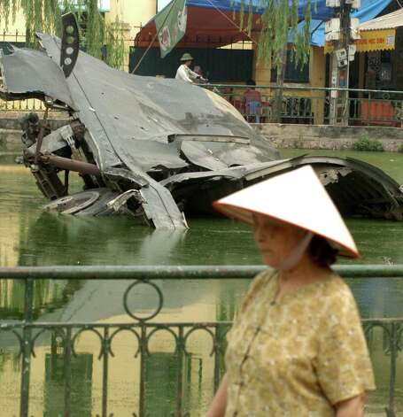 A woman walks near the wreckage of a B-52 in a small lake in Hanoi, Vietnam on Nov. 15, 2006. The bomber was  shot down in 1972. Photo: SHAH
 MARAI, AFP/Getty Images / 2006 AFP