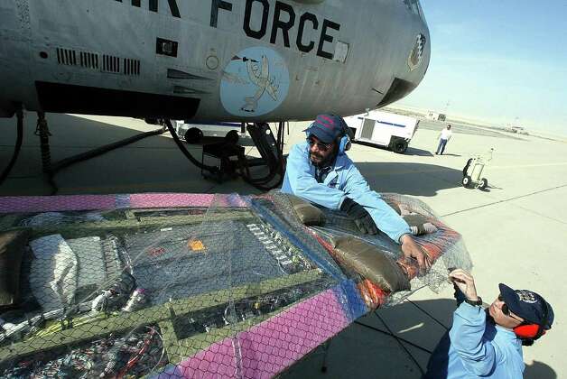Engineering technicians Casey
 Tull (right) and Charlie Nichols wrap up the  X-43 research vehicle, which is mated to a B-52 during test-flight prep on March 24 2004 at Edwards Air Force Base in California. Photo: ROBYN BECK, AFP/Getty Images / 2004 AFP