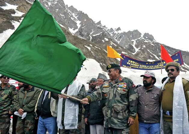 Chief commander of India's Srinagar-based 15 Army Corps Signals Syed Ata Hasnain flags off vehicles departing on the newly-reopened Srinagar-Leh highway in Zojila, about 67 miles east of Srinagar, on Wednesday. The 275-mile highway was opened for the season by Indian Army authorities after remaining snow at Zojila Pass, some 11,581 feet above sea level, had been cleared. The pass connects Kashmir with the Buddhist-dominated Ladakh region, a famous tourist destination among foreign tourists for its monasteries, landscapes and mountains. AFP PHOTO/Tauseef MUSTAFA Photo: TAUSEEF MUSTAFA, AFP/Getty Images / 2012 AFP