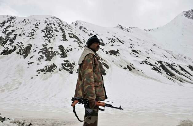 An Indian soldier keeps watch along the Srinagar-Leh highway in Zojila, about 67 miles east of Srinagar, on Wednesday. The 275-mile highway was opened for the season by Indian Army authorities after remaining snow at Zojila Pass, some 11,581 feet above sea level, had been cleared. The pass connects Kashmir with the Buddhist-dominated Ladakh region, a famous tourist destination among foreign tourists for its monasteries, landscapes and mountains. AFP PHOTO/Tauseef MUSTAFA Photo: TAUSEEF MUSTAFA, AFP/Getty Images / 2012 AFP