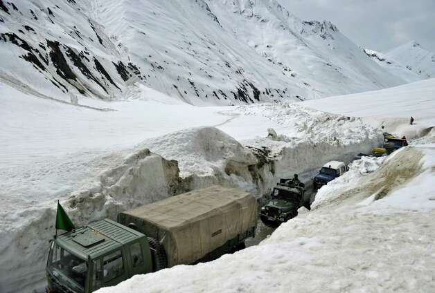 Military vehicles ply the Srinagar-Leh highway in Zojila, about 67 miles east of Srinagar, on Wednesday. The 275-milehighway was opened for the season by Indian Army authorities after remaining snow at Zojila Pass, some 11,581 feet above sea level, had been cleared. The pass connects Kashmir with the Buddhist-dominated Ladakh region, a famous tourist destination among foreign tourists for its monasteries, landscapes and mountains. AFP PHOTO/Tauseef MUSTAFA Photo: TAUSEEF MUSTAFA, AFP/Getty Images / 2012 AFP
