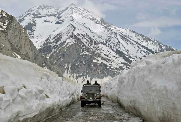 An Indian Army jeep plies the Srinagar-Leh highway in Zojila, about 67 miles east of Srinagar, on Wednesday. The 275-mile highway was opened for the season by Indian Army authorities after remaining snow at Zojila Pass, some 11,581 feet above sea level, had been cleared. The pass connects Kashmir with the Buddhist-dominated Ladakh region, a famous tourist destination among foreign tourists for its monasteries, landscapes and mountains. AFP PHOTO/Tauseef MUSTAFA Photo: TAUSEEF MUSTAFA, AFP/Getty Images / 2012 AFP