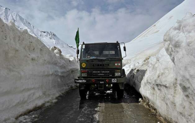 An Indian Army truck plies the Srinagar-Leh highway in Zojila, about 67 miles east of Srinagar, on Wednesday. The 275-mile highway was opened for the season by Indian Army authorities after remaining snow at Zojila Pass, some 11,581 feet above sea level, had been cleared. The pass connects Kashmir with the Buddhist-dominated Ladakh region, a famous tourist destination among foreign tourists for its monasteries, landscapes and mountains. AFP PHOTO/Tauseef MUSTAFA Photo: TAUSEEF MUSTAFA, AFP/Getty Images / 2012 AFP