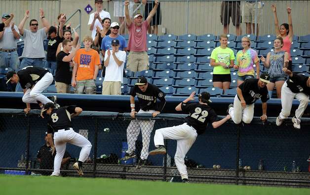 Trumbull players hop over the dugout fence after winning Saturday's FCIAC baseball championship game against Greenwich at the Ballpark at Harbor Yard in Bridgeport on May 26, 2012. Photo: Lindsay Niegelberg / Stamford Advocate