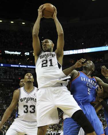 San Antonio Spurs' Tim Duncan (21) pulls in a rebound against Oklahoma City Thunder's Kendrick Perkins (5) and San Antonio Spurs' Boris Diaw (33) during the first half of game two of the NBA Western Conference Finals in San Antonio, Texas on Tuesday, May 29, 2012. Kin Man Hui/Express-News (Kin Man Hui / San Antonio Express-News) / SA