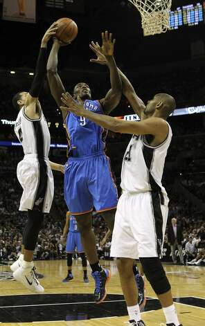 Oklahoma City Thunder's Serge Ibaka (9) shoots against San Antonio Spurs' Danny Green (4) and San Antonio Spurs' Tim Duncan (21) during the first half of game two of the NBA Western Conference Finals in San Antonio, Texas on Tuesday, May 29, 2012. Kin Man Hui/Express-News (Kin Man Hui / San Antonio Express-News) / SA
