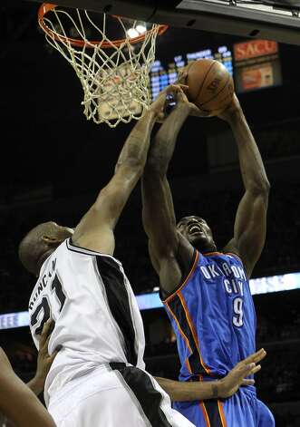 San Antonio Spurs' Tim Duncan (21) gets a hand on a shot by Oklahoma City Thunder's Serge Ibaka (9) during the first half of game two of the NBA Western Conference Finals in San Antonio, Texas on Tuesday, May 29, 2012. Kin Man Hui/Express-News (Kin Man Hui / San Antonio Express-News) / SA
