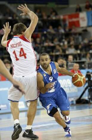 France's Tony Parker, center, is challenged by Croatia's Sandro Nicevic during their EuroBasket 2009, European Basketball Championships group E qualifying round match in Bydgoszcz, Poland, Sunday Sept. 13, 2009. (Darko Vojinovic / Associated Press) / SA