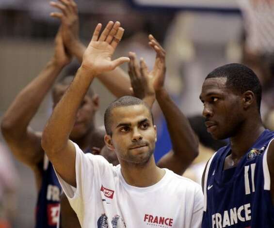 France's Tony Parker, left, waves to fans beside team mate Florent Pietrus after their loss to Argentina in their first round match at the world basketball championships in Sendai August 19, 2006. (Marcos Brindicci / Reuters) / SA