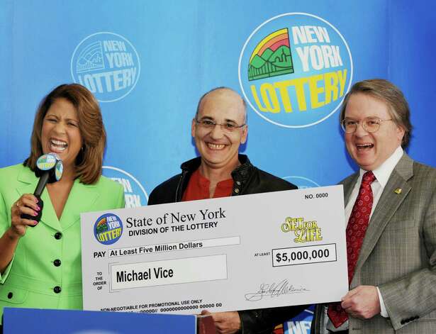 Michael Vice, of Ticonderoga, center, smiles and holds the supersized check as he meets with the media with lottery spokesperson Yolanda Vega, left, and the Director of the New York Lottery, Gordon Medenica, right, on Tuesday, March 9, 2010, at New York Lottery Headquarters in Schenectady, NY.  The lottery held the press conference to present Vice, who won the "Set for Life" instant game at C&G Petroleum In his hometown of Ticonderoga that guarantees him a minimum of a $5,000,000 jackpot.  Vice will receive 20 annual payments to total the $5 million, and if he lives past the 20 years he will net a check of $171,678 for each additional year he survives.  The 46 year old is the first in Essex County to win a Lottery Jackpot in 2010.   (Luanne M. Ferris / Times Union) Photo: LUANNE M. FERRIS / 00007815A