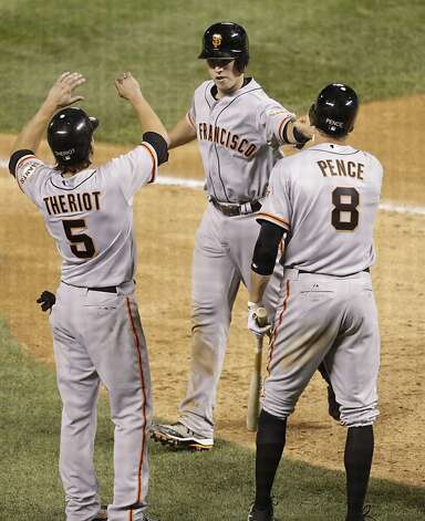 Ryan Theriot and Hunter Pence congratulate Buster Posey after his three-run homer in the Giants' six-run eighth inning. Photo: Joe Mahoney, Associated Press / SF