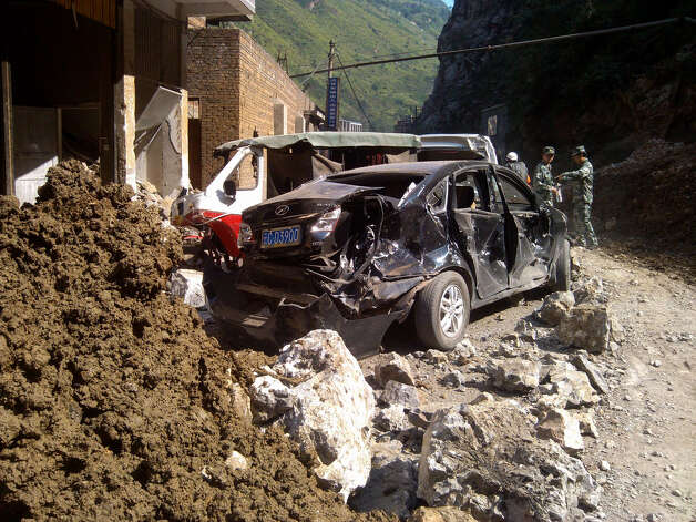 In this photo provided by China's Xinhua News Agency, damaged cars are seen in Luozehe town, Yiliang County, southwest China's Yunnan Province, Friday. A series of earthquakes collapsed houses and triggered landslides in a remote mountainous part of southwestern China on Friday, killing dozens of people with the toll expected to rise. Damage was preventing rescuers from reaching some outlying areas, and communications were disrupted. (AP Photo/Xinhua, Zhou Hongpeng) Photo: Ap/getty / SL