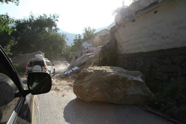 A boulder lies on a road in Yiliang, southwest China's Yunnan province on Friday following two shallow quakes that struck the remote and mountainous border area of Yunnan and Guizhou province of southwest China.   Dozens of people were killed and 550 injured when two shallow quakes with a magnitude of both at 5.6 struck a remote and mountainous area of southwest China, toppling buildings and sparking chaos in the streets, officials said. (Photo credit should read AFP/AFP/GettyImages) Photo: AFP, Ap/getty / 2012 AFP