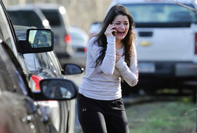 A woman waits to hear about her sister, a teacher, following a shooting at the Sandy Hook Elementary School in Newtown, Conn., about 60 miles (96 kilometers) northeast of New York City, Friday, Dec. 14, 2012. An official with knowledge of Friday's shooting said 27 people were dead, including 18 children. It was the worst school shooting in the country's history. Photo: Jessica Hill / Associated Press