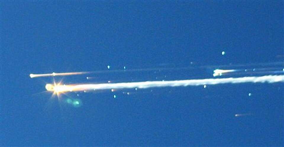 In this Feb. 1, 2003 file photo, debris from the space shuttle Columbia streaks across the sky over 