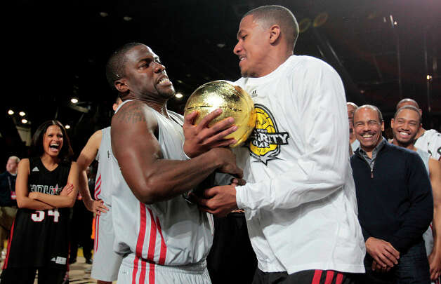 (l-r) After being named MVP of the Celebrity game comedian Kevin Hart fights actor Nick Cannon for the MVP trophy during the 2013 Sprint All-Star Celebrity game. Photo: Billy Smith II, Houston Chronicle / © 2013 Houston Chronicle