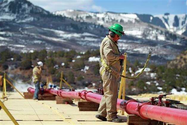 In this March 29, 2013 photo, a worker helps monitor water pumping pressure and temperature, at the site of a natural gas hydraulic fracturing and extraction operation run by Encana Oil &amp; Gas (USA) Inc., outside Rifle, in western Colorado. Proponents of hydraulic fracturing point to the economic benefits from vast amounts of formerly inaccessible hydrocarbons the process can extract. Opponents point to potential environmental impacts, with some critics acknowledging that some fracking operations are far cleaner than others. Photo: Brennan Linsley, AP / AP