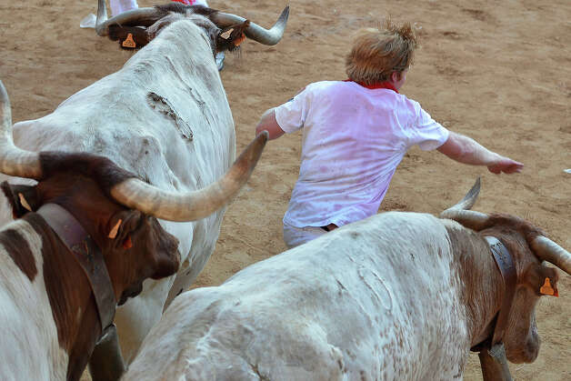 A participant runs in front of Dolores Aguirre's bulls during a bull run of the San Fermin Festival in Pamplona, northern Spain, on July 8, 2013. The festival is a symbol of Spanish culture that attracts thousands of tourists to watch the bull runs despite heavy condemnation from animal rights groups. Photo: PEDRO ARMESTRE, AFP/Getty Images / 2013 AFP