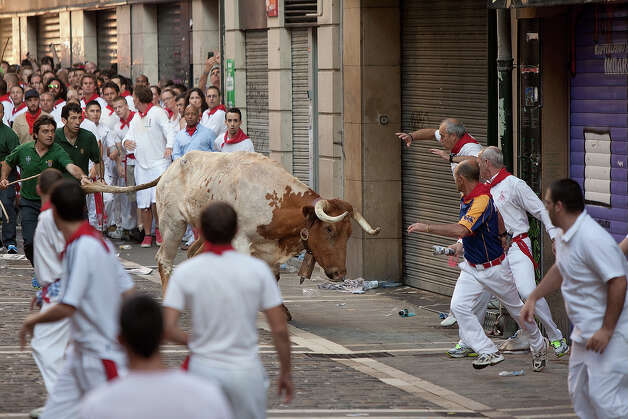 A steer runs towards revellers during the Dolores Aguirre's ranch fighting bulls running near Curva Estafeta on the third day of the San Fermin Running Of The Bulls festival, on July 8, 2013 in Pamplona, Spain. The annual Fiesta de San Fermin, made famous by the 1926 novel of US writer Ernest Hemmingway 'The Sun Also Rises', involves the running of the bulls through the historic heart of Pamplona for nine days from July 6-14. Photo: Pablo Blazquez Dominguez, Getty Images / 2013 Getty Images