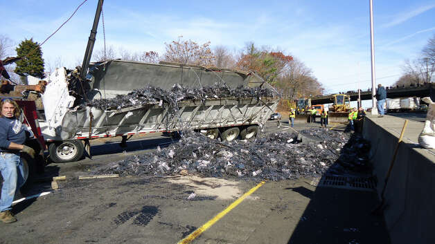 This tractor-trailer dump truck flipped over and spilled its cargo of scrap metal on Interstate 95, between southbound Exits 14 and 13, on Wednesday morning -- shutting down the highway for about four hours. Photo: Norwalk Fire Department / Westport News contributed