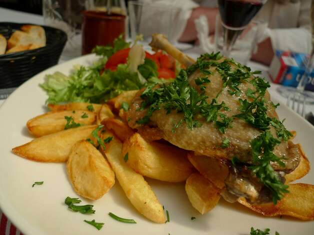A plate of duck confit and frites from a bistro table in Passage des Panoramas. Photo: Spud Hilton, The Chronicle