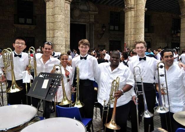 The Greenwich High School wind ensemble's trombone section gathers with the trombone section of the National Band of Cuba after the two groups' combined performance in April 2014. The GHS students, in bow ties, left to right, are Aaron Kim, Paul Collins and Ben Albano. Photo: Picasa, Contributed Photo / Greenwich Time Contributed