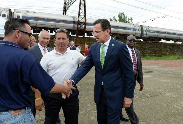 Gov. Dannel P. Malloy was in Bridgeport Wednesday, July 16, 2014, to announce funding for a new train station at the site of the former Remington Arms factory on the south side of Barnum Avenue.  Local 478 business representative Duane Gates, center, introduces Gov. Malloy to Michael Robinson, the business representative for the greater Bridgeport area of the Local 210's Carpenter Union following a press conference. Photo: Autumn Driscoll / Connecticut Post