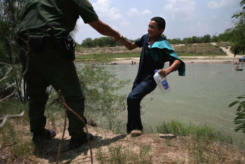 A U.S. Border Patrol agent assists an unaccompanied 13-year-old from El Salvador after he crossed the Rio Grande into the United States on Thursday near Mission, Texas.