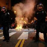 Riot police officers try to tame the scene after Giants fans riot in the streets at 22nd and Mission after the San Francisco Giants win the World Series against the Kansas City Royals Wednesday, October 29, 2014.