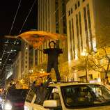 A Giants fan stands on a moving car downtown when revelers flooded the streets after the San Francisco Giants beat the Kansas City Royals 3-2 in Game 7 of the World Series at Civic Center Plaza in San Francisco, Calif. on October 29, 2014.