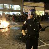 Police in riot gear keep revelers away from a bonfire on Mission Street in San Francisco after the Giants win the World Series on Wednesday, October 29, 2014.