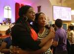 Sisters Julia and Lydia Anglin, of Katy, hug after giving an offering at the Texas Conference Ministers Alliance Houston Ecumenical Prayer Vigil at the Wesley African Methodist Episcopal Church Saturday, June 20, 2015, in Houston. The vigil was held in memory of the nine victims killed in the shooting at Emanuel AME Church in Charleston, South Carolina.