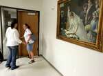 A traditional husband and wife wedding painting hangs on the wall of the County Clerks Office while Carly Kinslow, left, and partner Jenifer Wegley, of Katy, exit after filing for a marriage license at Harris County Civil Courthouse Friday, June 26, 2015, in Houston. The Supreme Court of the United States on Friday ruled that same-sex couples can marry nationwide.