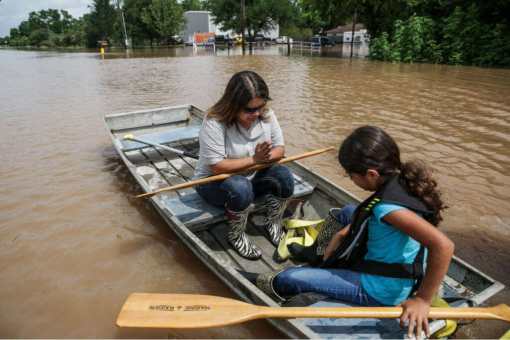 A woman and a girl travel through the flooded town of Booth, Texas on Wednesday, June 1, 2016. Residents and local wildlife could be seen attempting to flee the rising flood waters. Photo: Michael Ciaglo/Houston Chronicle