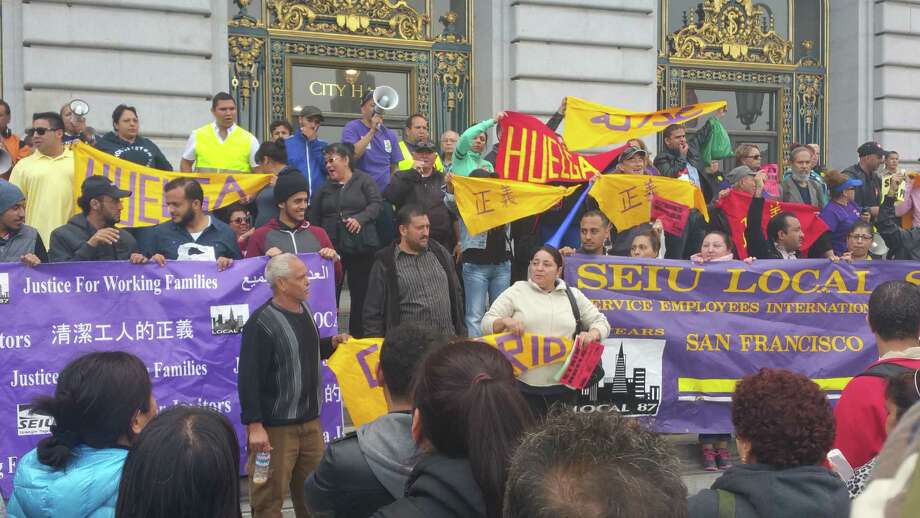 Janitors wait outside of San Francisco’s city hall amid contract negotiations with their union representatives and cleaning companies that employ them on Wednesday, August 3, 2016. The workers received a pay raise, union officials said.