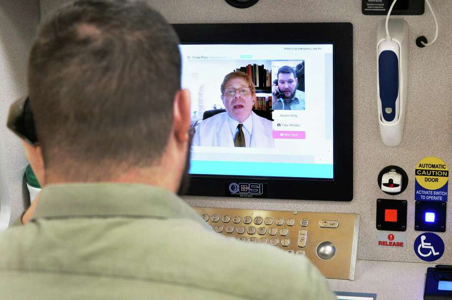 Store pharmacist Michael Zappone, left, speaks with Dr. Craig Price of New Jersey during a demonstration of a new telemedicine option “Doctor on Demand” in New Jersey. The option in Texas is hampered by outdated regulations. Photo: John Carl D'Annibale /Albany Times Union / 10035204A