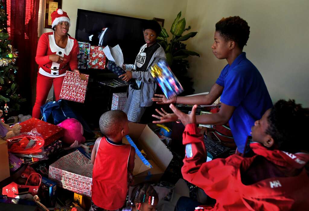 Tyshika Britten tosses gifts to one of her sons waiting with open arms. Photo: Michael S. Williamson/The Washington Post
