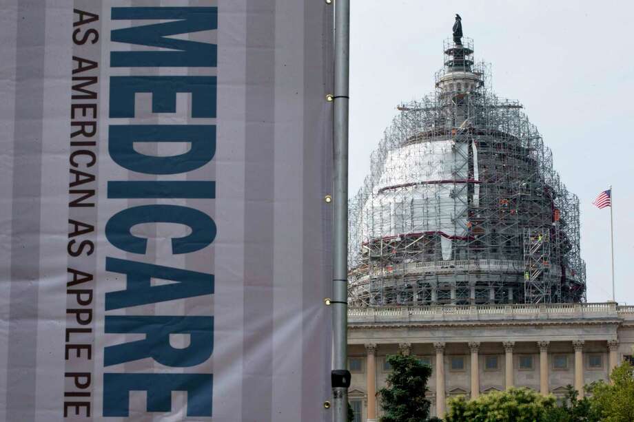 FILE - In this July 30, 2015 file photo, a sign supporting Medicare is seen on Capitol Hill in Washington. A government report says Medicare beneficiaries can end up with higher hospital bills for some medical services as outpatients than as inpatients. In the topsy-turvy world of Medicare billing, you may pay more for outpatient care. (AP Photo/Jacquelyn Martin, File) Photo: Jacquelyn Martin, STF / Copyright 2016 The Associated Press. All rights reserved. This material may not be published, broadcast, rewritten or redistribu