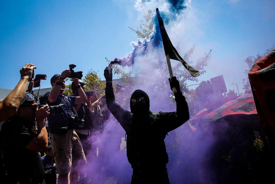 An anarchist holds a smoke bomb after the police retreat during a protest at Martin Luther King Jr. Civic Center park in Berkeley, Calif., on Sunday, August 27th, 2017. Photo: Gabrielle Lurie, The Chronicle