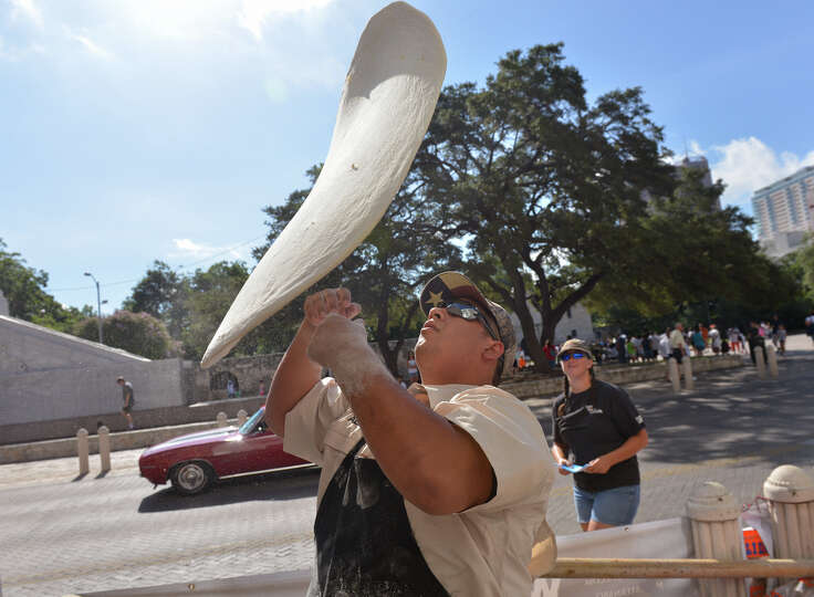 Alex Rymers of Dirt Road Cookers tosses dough in front of the Guinness museum during an attempt t