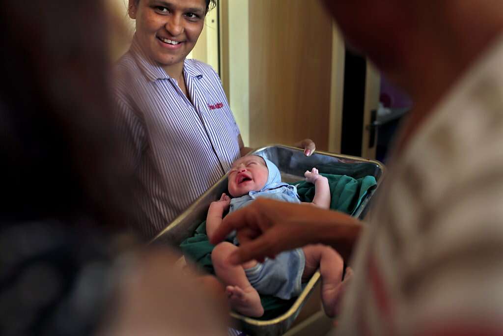 Hospital helper Hansa Harjan, center, shows baby Kyle Benito Kowalski to his mom Jennifer Benito-Kowalski, left, and grandmother Sue Kowalski for the first time at the Akanksha Infertility Clinic in Anand, India, Thursday, May 23, 2013. Photo: Nicole Fruge, The Chronicle