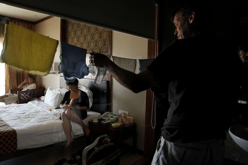 Steve Kowalski hangs laundry in his hotel room at the Madhubhan Resort and Spa, as his wife Jennifer and mom Sue look on, in Anand, India, Thursday, May 30, 2013. Steve and Jennifer were beginning to miss the confronts of home, particularly their washer and dryer. Photo: Nicole Fruge, The Chronicle